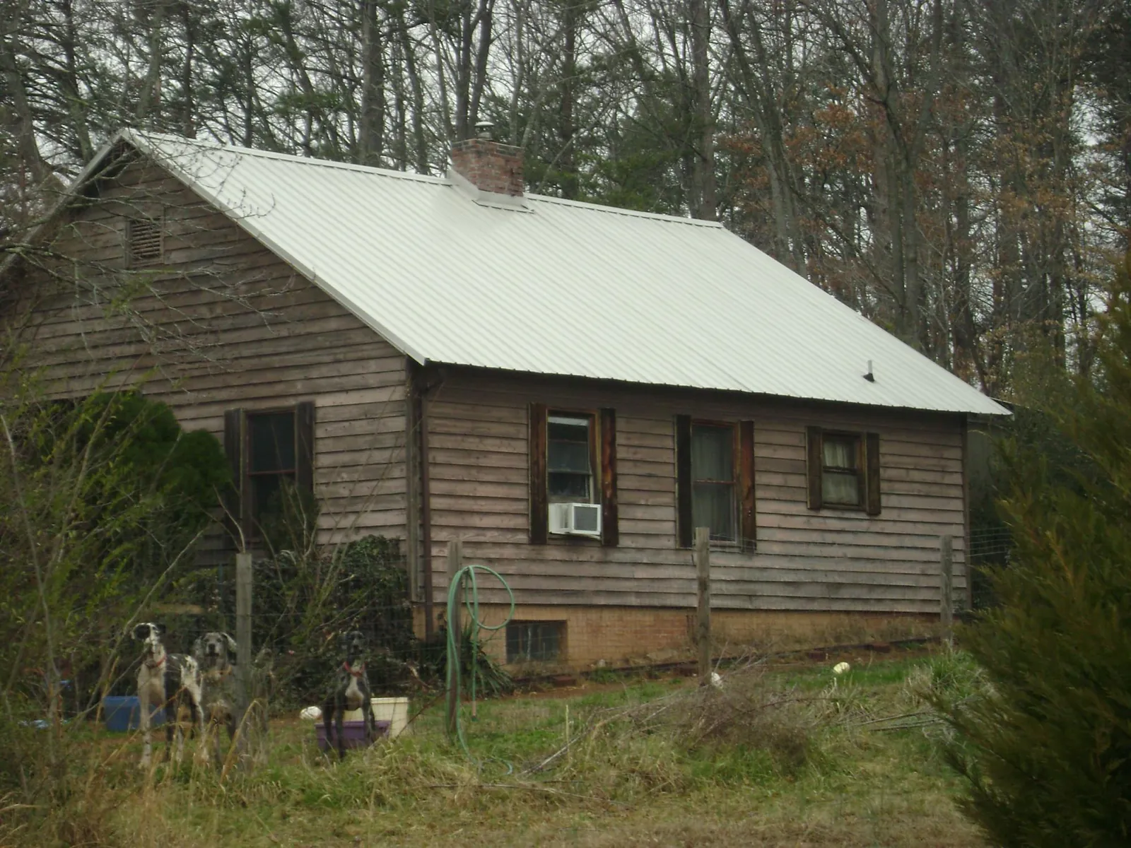 White metal roof on an old wood sided farmhouse, from a Metal Roof Installation job in Henderson